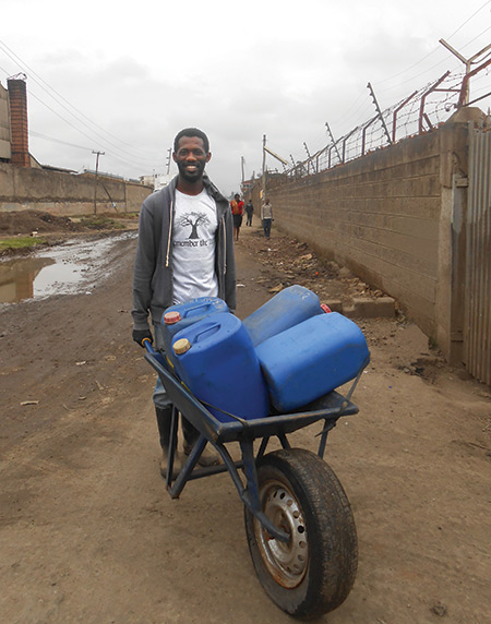 William Tarpeh with a wheelbarrow, working on a sanitation project in Nairobi, Kenya.