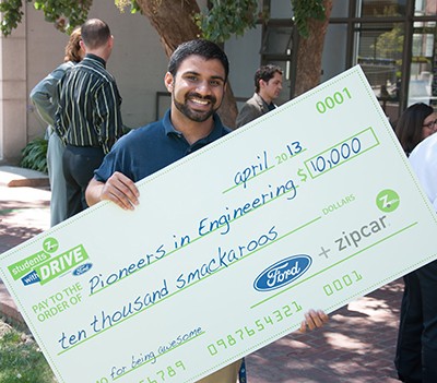 Pioneers in Engineering (PiE) director Baladitya Yellapragada accepts a $10,000 check after PiE won the “Students with Drive” contest sponsored by Zipcar and Ford. (Photo courtesy PiE)