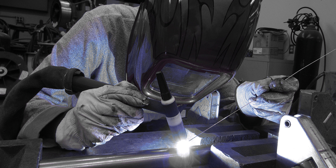Student welding steel bridge component