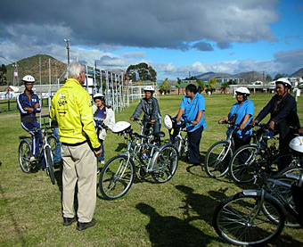 POWER OF THE PEDAL: De Waal (in yellow) instructs government health care workers about bicycle maintenance and safety. Workers who receive BEN bikes now visit up to 550 patients a month (and spend more time with them), compared with the 100 to 200 patients they previously served on foot. Courtesy Louis de Waal