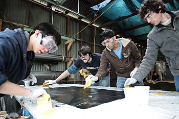 DEDICATED: The 73-member CalSol team has spent long days and nights on the Impulse project. Here, a crew works on infusing carbon fiber with epoxy resin for the shell layup in the background. From left: Kyle Chiang, Amando Miller, Shail Shah and Ed Divita. MATTHEW FARRELL
