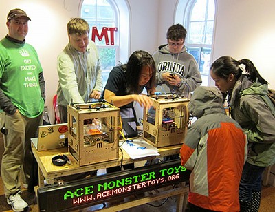 Fernandez (center) and Ace Monster Toys colleagues explain to young makers how to use a Makerbot 3D printer. (Photo courtesy Christian Fernandez)