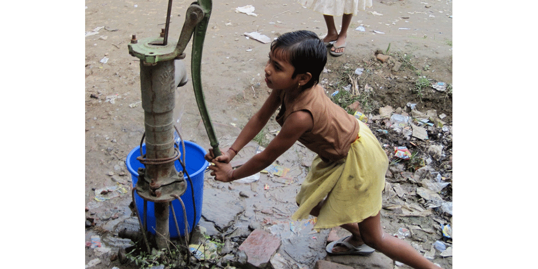 Girl in India pumping water
