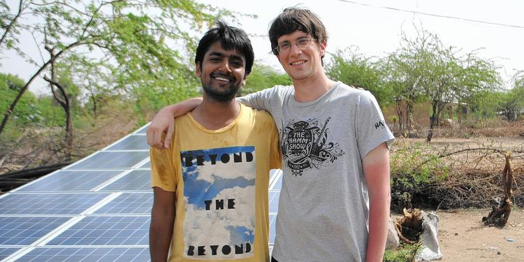 Yashraj Khaitan, left, and Jacob Dickinson, co-founders of Gram Power, stand next to several solar panels in India