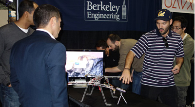graduate student Aislan Foina discusses drones with Expo attendees