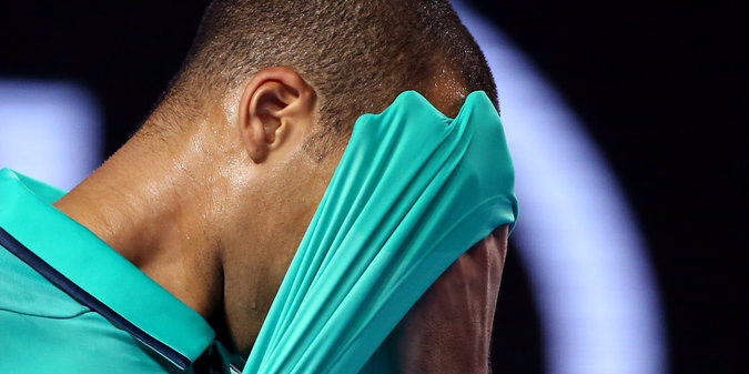 French tenis player Jo-Wilfried Tsonga wipes sweat from his face during the Australian Open.