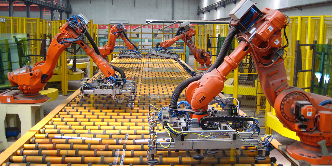 Robots unloading float glass on an assembly line.