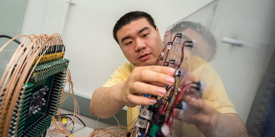 Chengzhi Shi checks the connections between the transducer array and the digital circuit.