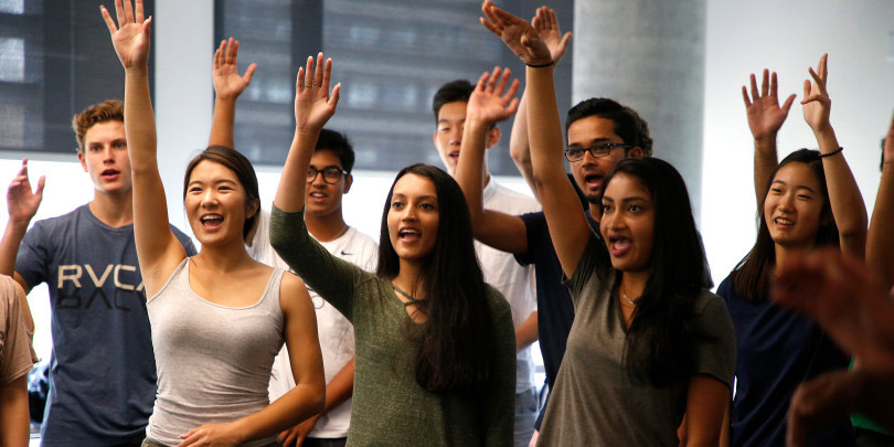 Students in an MET class raise their hand