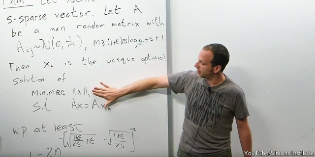 Presentating equations on a whiteboard at NIPS conference