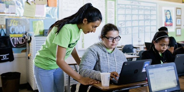 Stephanie Tena teaches middle schooler Bianca Castro coding and AI during an after- school club