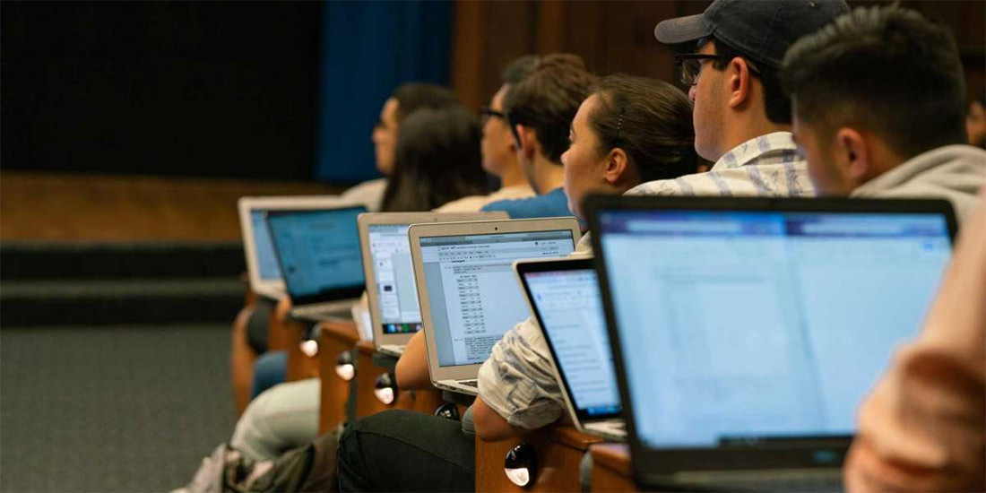 Students with computers listen to a lecture in David Wagner