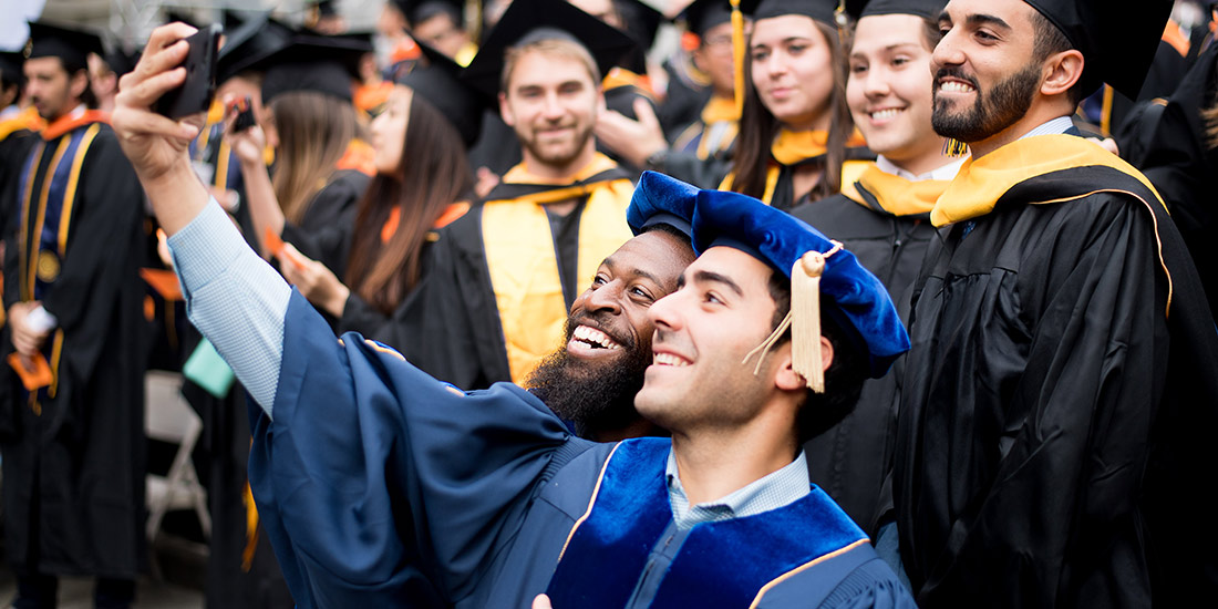 Ph.D. graduates taking a selfie at commencement