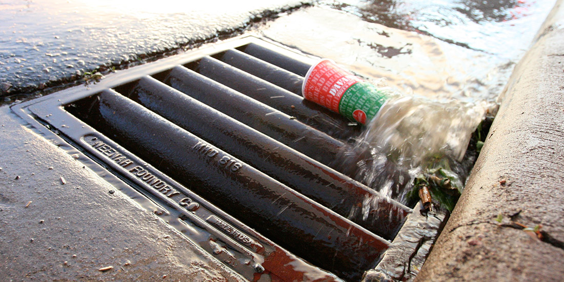 Discarded cup carried to storm drain by runoff water