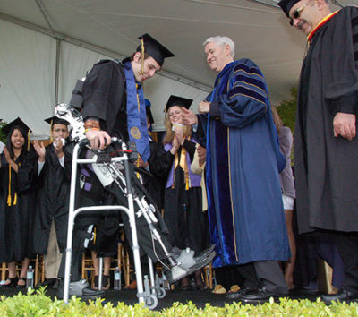 Austin Whitney walks across the stage at commencement