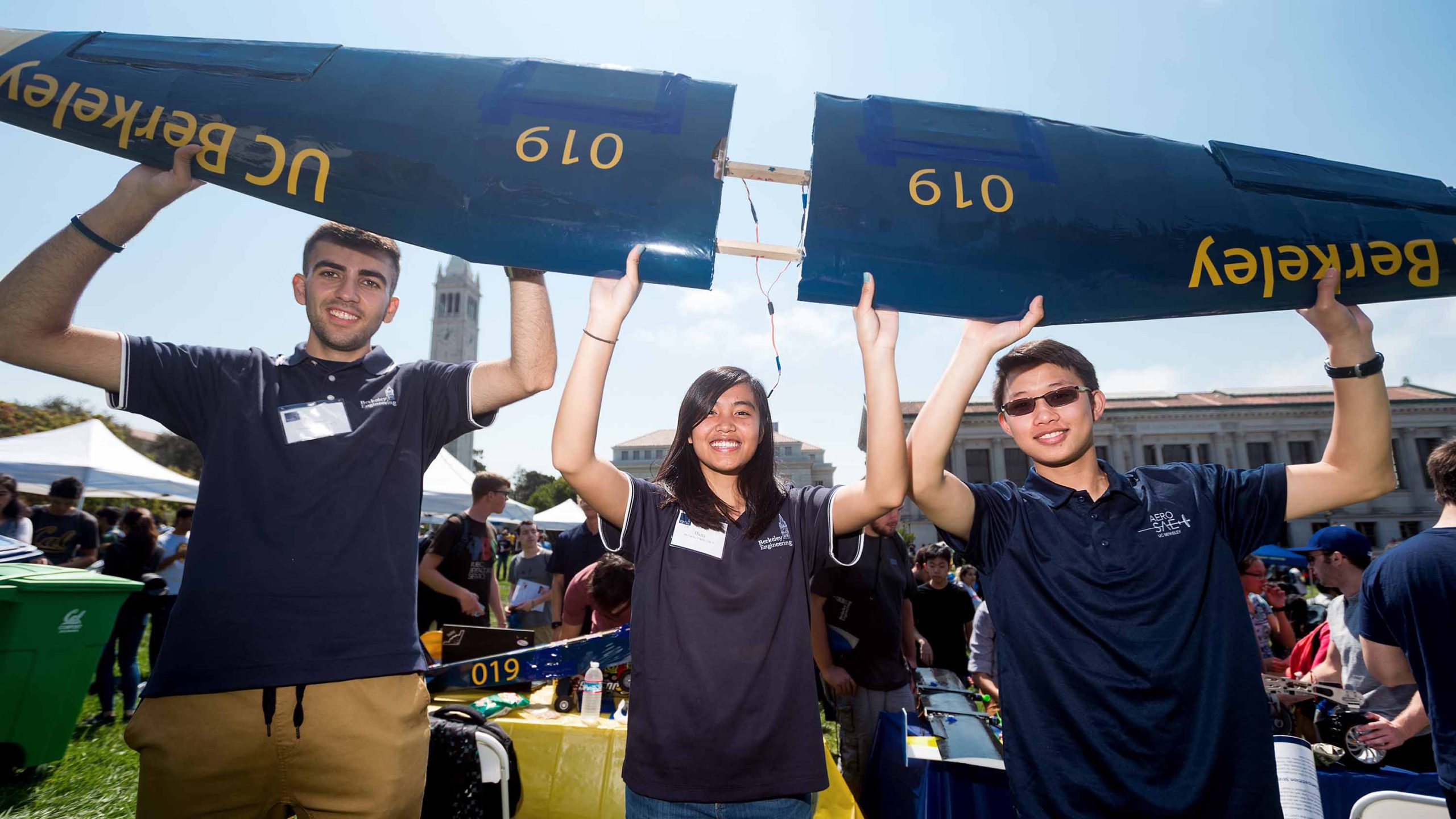 Aerospace SAE club members holding a wing from one of their planes