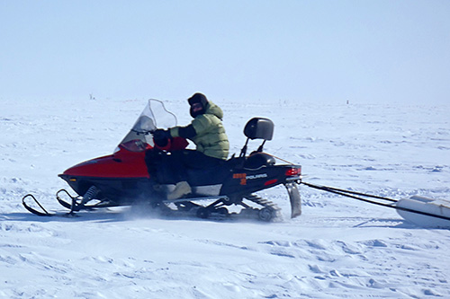 Hubbard uses snowmobiles to pull geophysical sensors across the Arctic tundra.