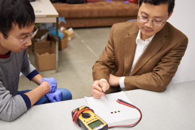 MSE professor Junqiao Wu and student examining ultrathin samples of material