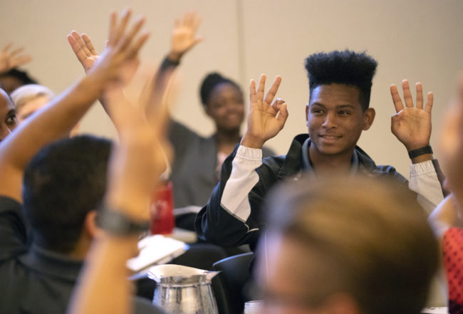 Participants in a NextProf Nexus workshop raise their hands