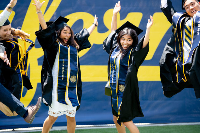 Happy graduates leaping in the air before commencement