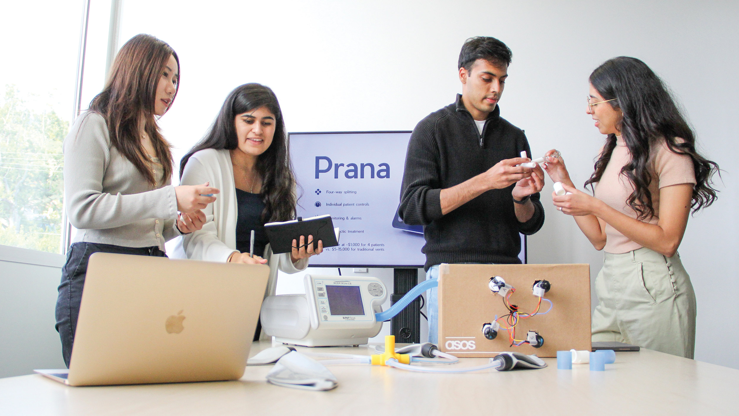 Prana team examing their ventilator device
