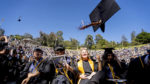 New graduates toss their mortarboards in the Greek Theatre during commencement