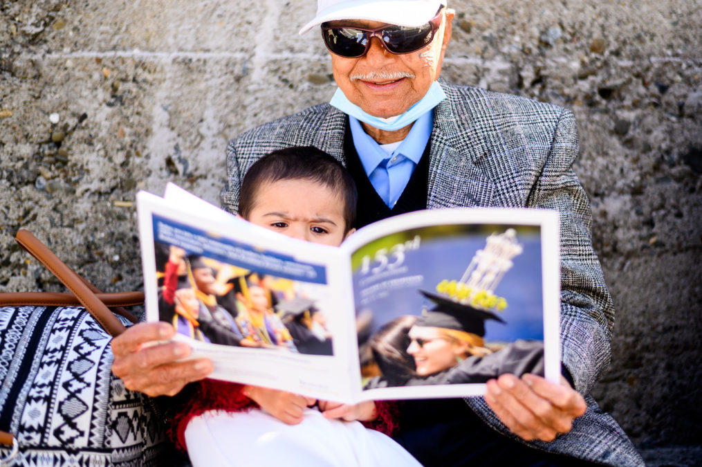 Baby and senior read a program in the Greek Theatre