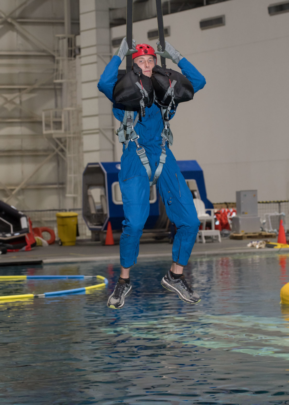 Hoburg hanging from a harness during water survival training