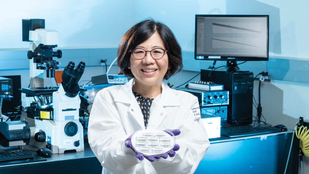 Lydia Sohn holding a petri dish containing small sensing deices in her lab.