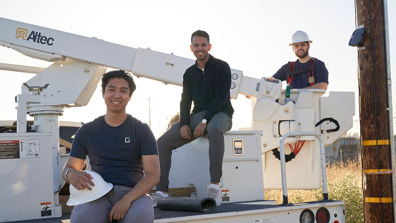 Photo of Gridware's founders posing on an aerial lift near a power pole with the Gridscope device mounted to it (left to right): Hall Chen, CTO; Abdulrahman Bin Omar, COO; Tim Barat, CEO. (Photo courtesy Gridware)