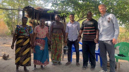 Photo showing three of the 11 members of the Yankho women’s co-op (left), the backbone of and inspiration for Umodzi, along with Brian Ndongera (third from right), an advisor to Umodzi, Mathews Tisatayane (second from right), founder and president, and Sean Mandell, co-founder and CEO.