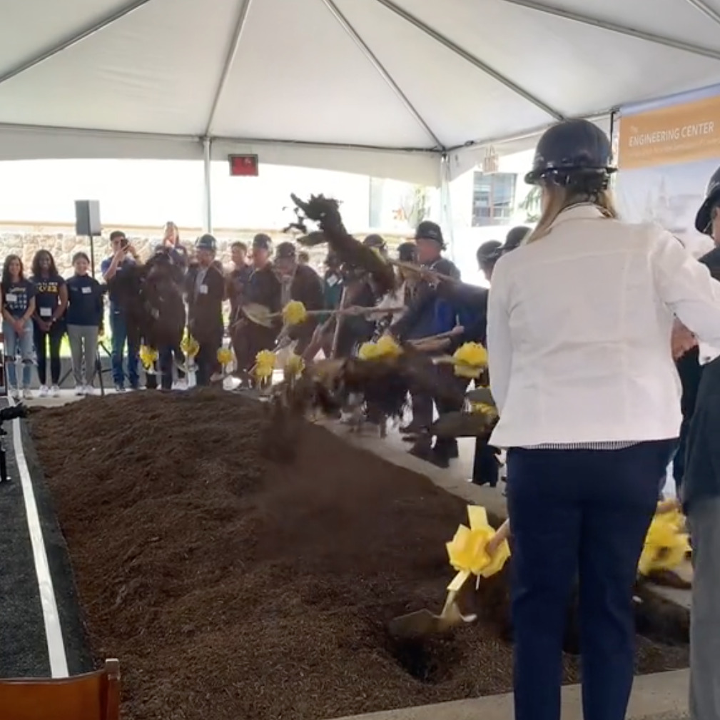 People shovel up dirt at the groundbreaking.