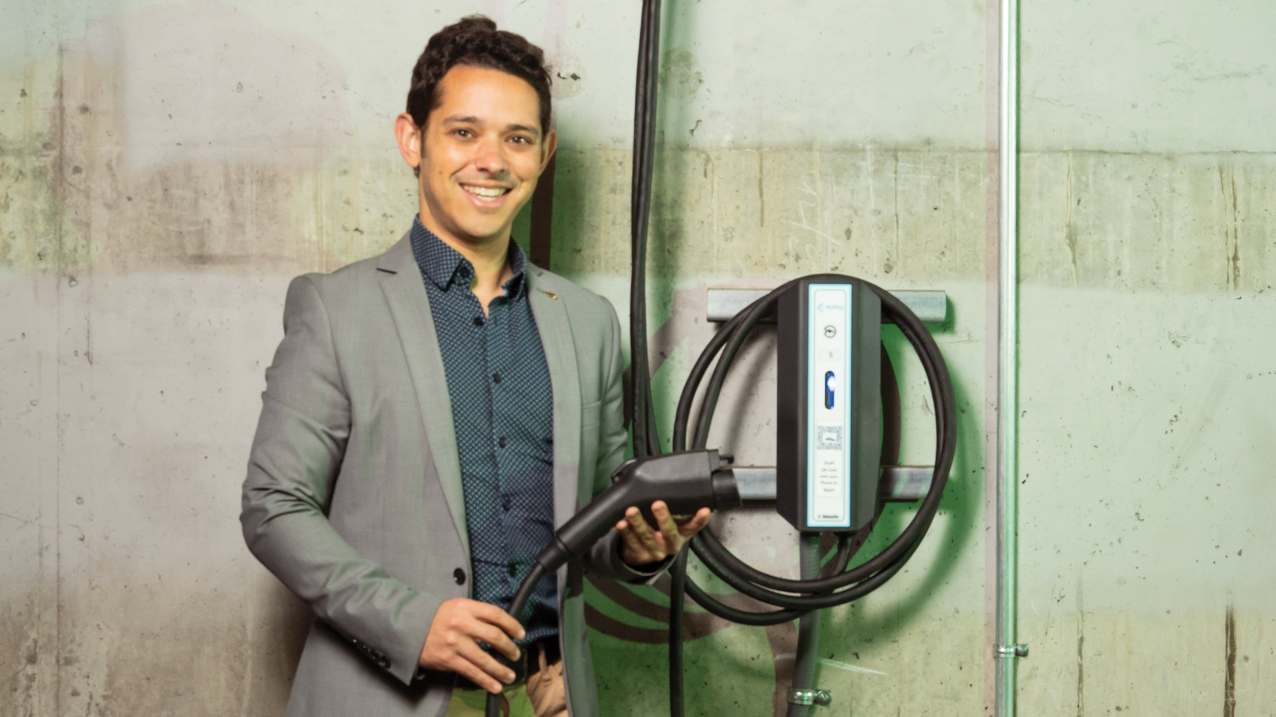 Scott Moura holding an electric car charger