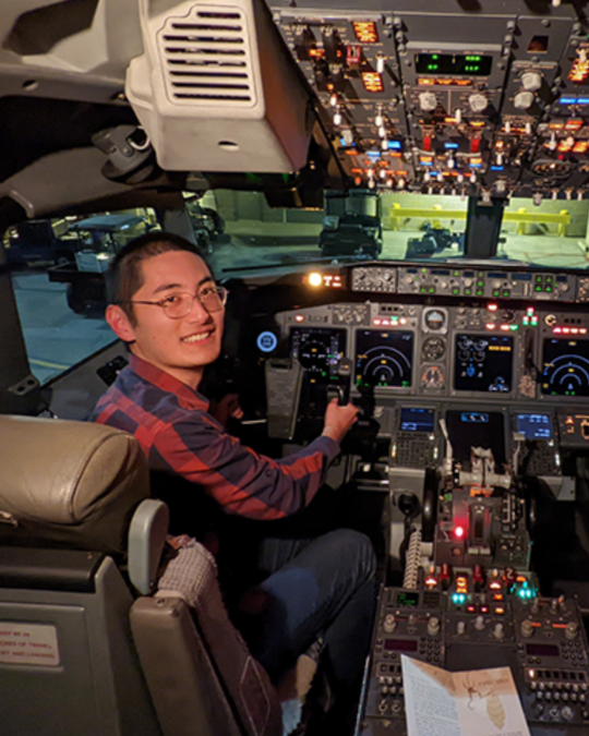 Bill Zhou seated in a plane cockpit.