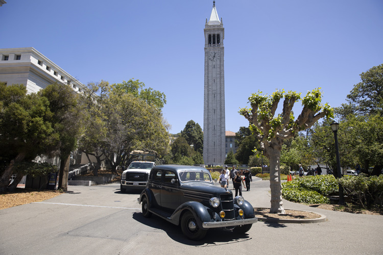 A 1935 Ford Phaeton parks in front of the Campanile during the Oppenheimer shoot on campus.