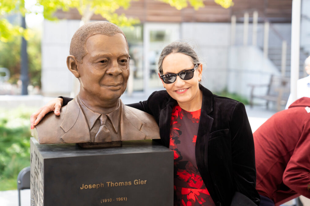 Maggie Crowley, newly retired EECS communications coordinator with the newly unveiled statue of Joseph Thomas Gier.