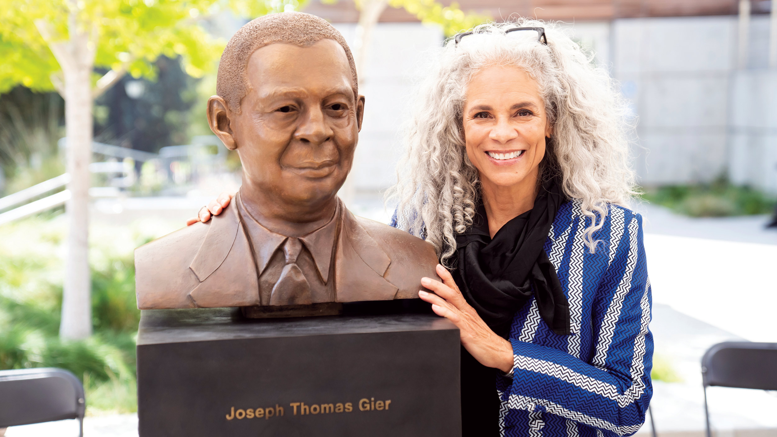 Sculptor Dana King poses with her bust of electrical engineering professor Joseph Gier.