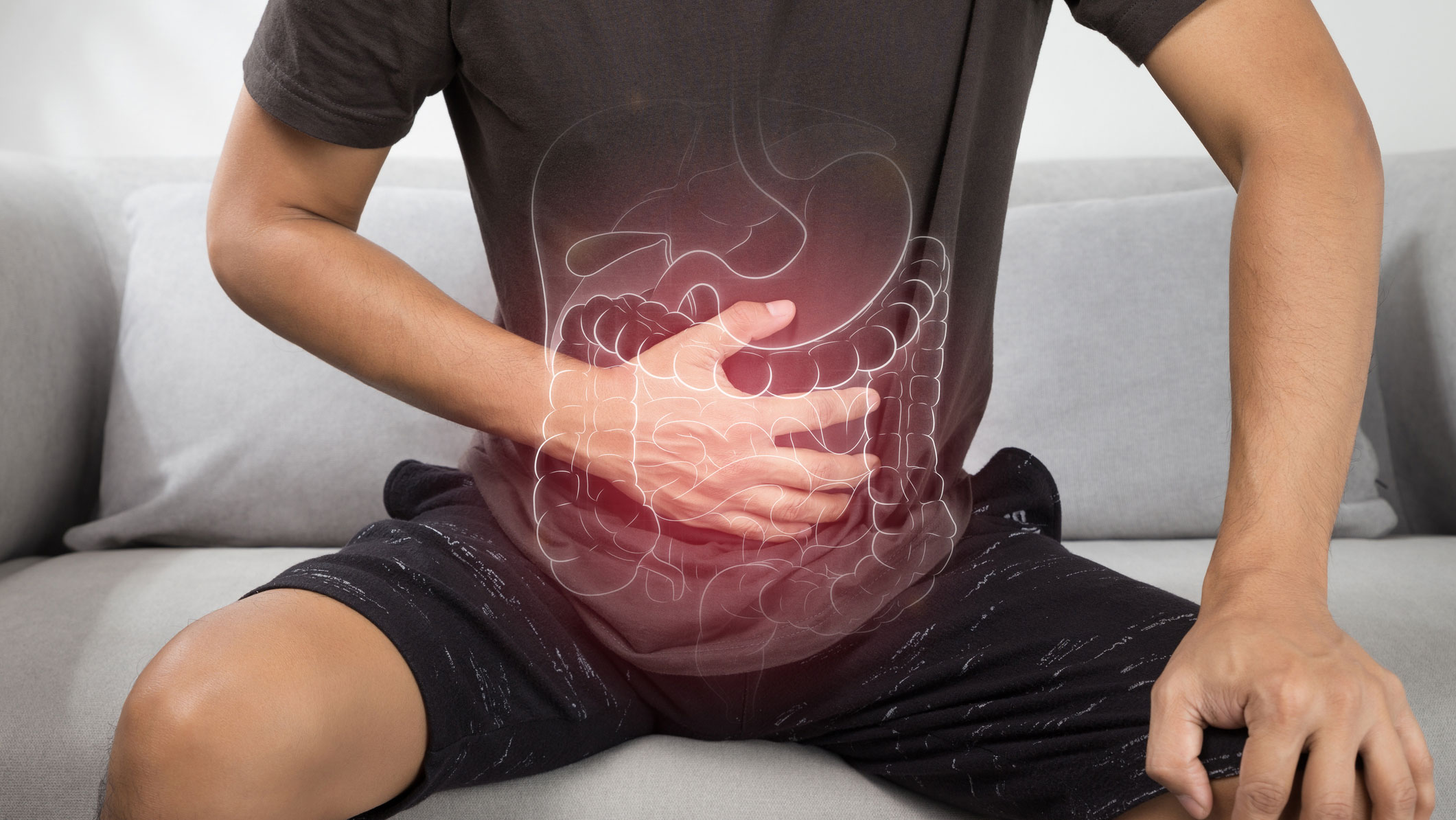 Photo of man grasping his abdominal area in pain with outline of colon superimposed on the area.