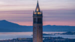 Photo of the Campanile, with its lights on during sunset.