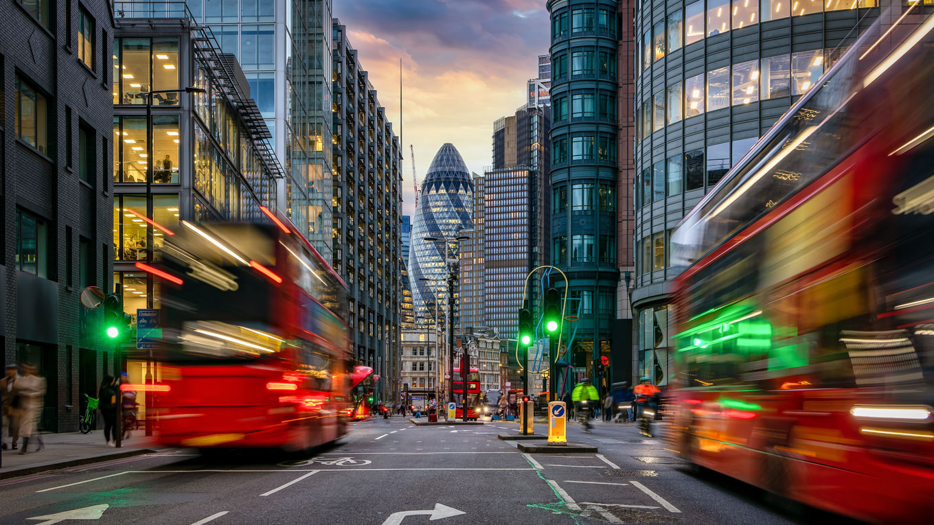 Sunset in London, England, with traffic light trails and illuminated skyscrapers.