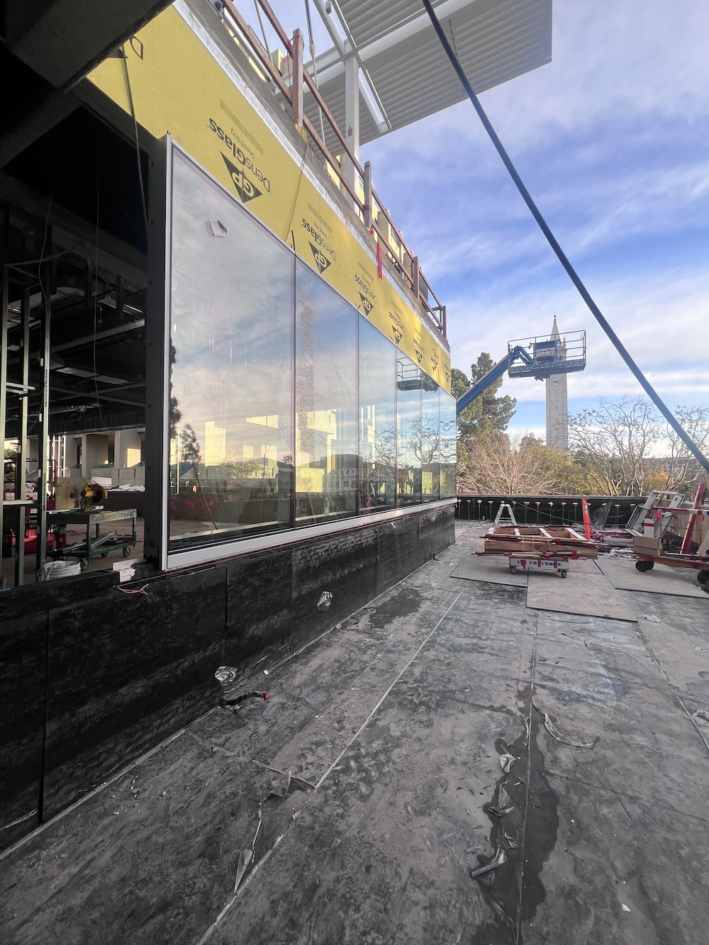 Glass walls being erected on the side of a building that is in progress