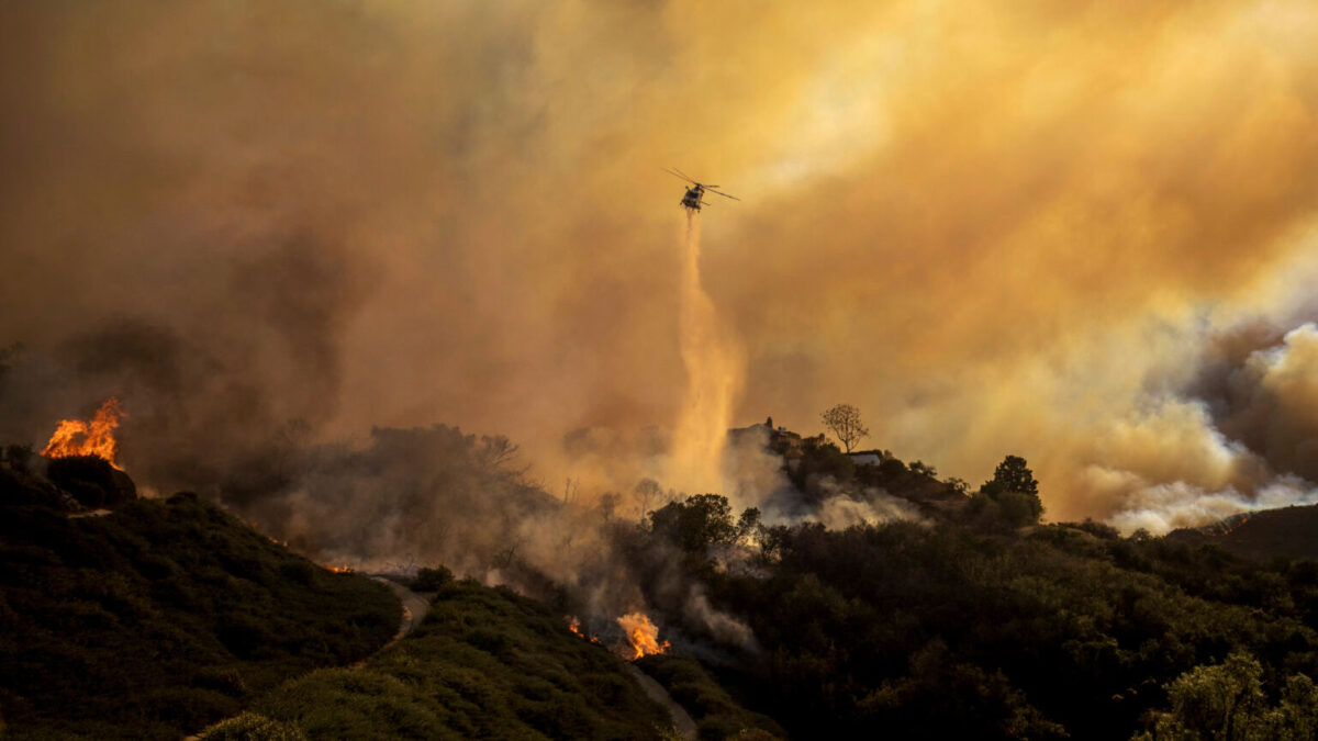 Water is dropped on the advancing Palisades Fire by helicopter in the Pacific Palisades neighborhood of Los Angeles.