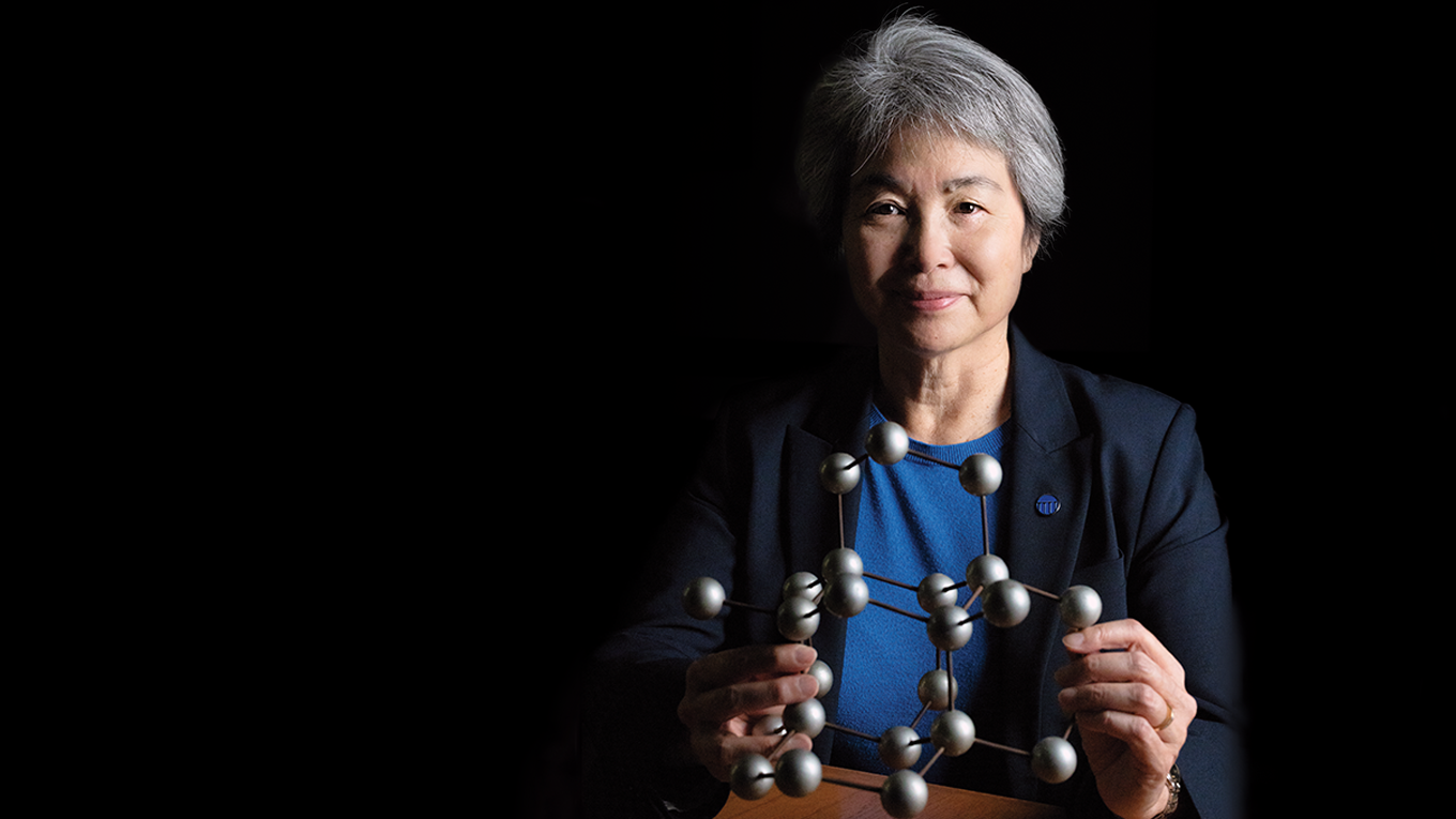 Dean Tsu Jae King Liu holding a molecule structure smiling at the camera