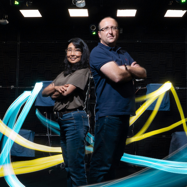 two people standing back to back with light rays around them