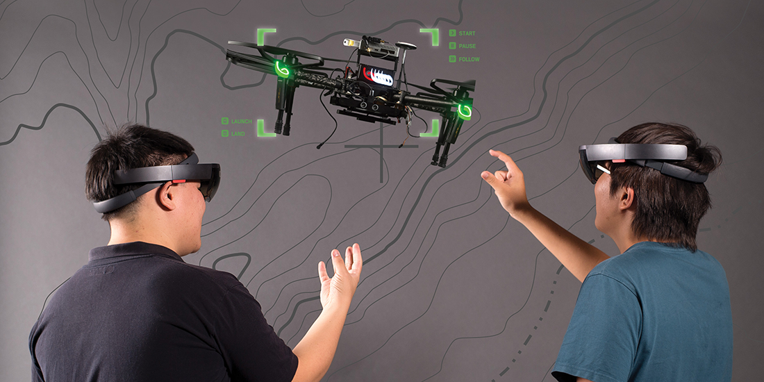 Men using augmented reality headsets to control a drone