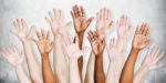 Raised hands in diverse skin tones
